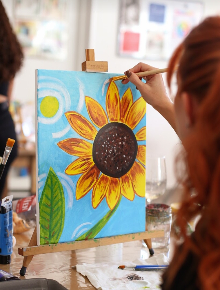 Alumna pintando girasol al óleo en clase
